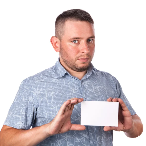 Attractive adult man with stubble in summer shirt in his hands holding a white sheet with space for advertising text on an isolated white background — Stock Photo, Image