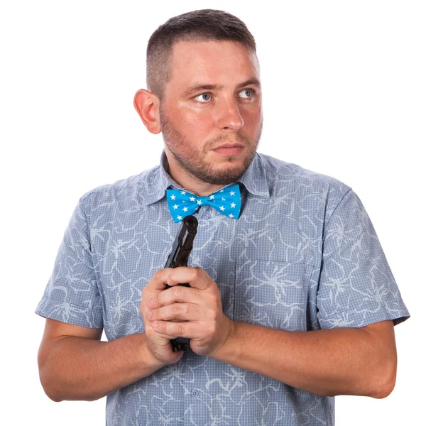 Homme adulte sérieux avec une barbe dans un nœud papillon bleu en chemise d'été avec une arme à feu dans les mains des mains sur un fond blanc isolé — Photo