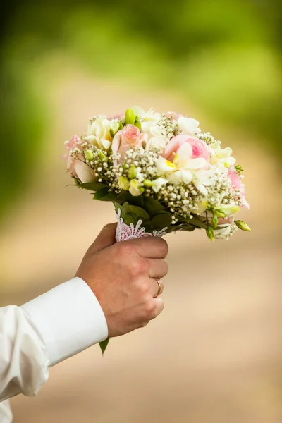 Male hands holding a bouquet of flowers — Stock Photo, Image