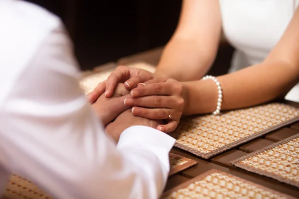 Hände eines liebenden Paares, das an einem Tisch in einem Café sitzt — Stockfoto