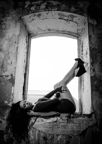 Dívka v krátkých šatech ležel s nohama v okně ol — Stock fotografie