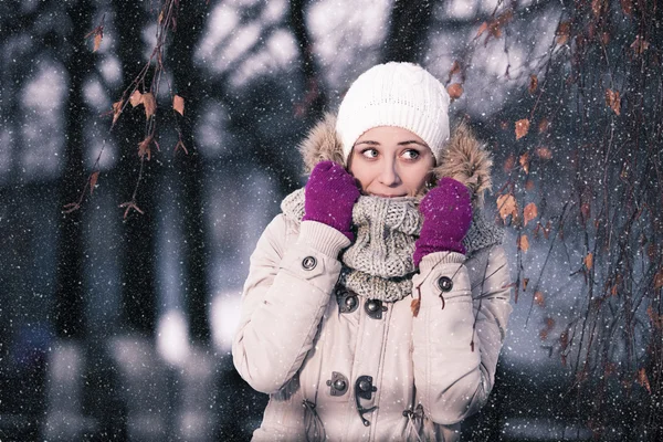 Flicka leker med snö i parken — Stockfoto