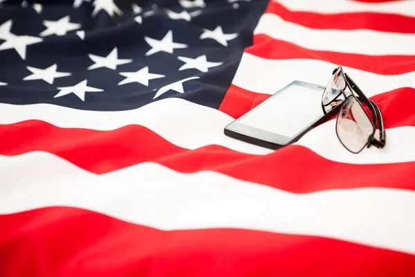 Black smartphone and glasses are on the US flag — Stock Photo, Image