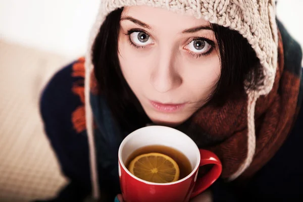 Un sorbo de café caliente en invierno. Una chica en un sombrero de punto holdi —  Fotos de Stock