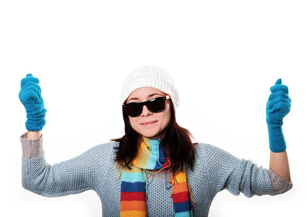 Fashionable girl in a knitted hat and sunglasses smiling and hol
