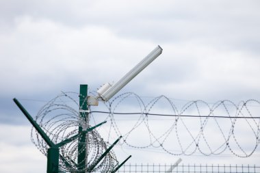 Beyaz arka plan üzerinde rulo dikenli teller ile Kablolu çit.