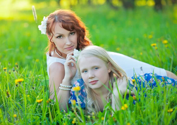 Молодая мать и ее маленькая дочь играют на траве — стоковое фото