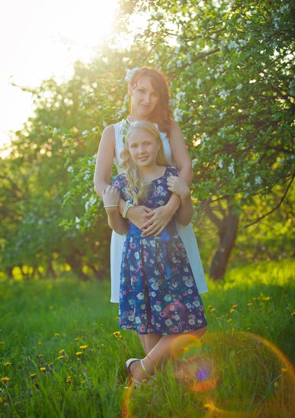 Мать и симпатичная девочка в цветущем саду — стоковое фото