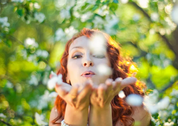 Romantische jonge vrouw in het voorjaar tuin onder appelbloesem. — Stockfoto