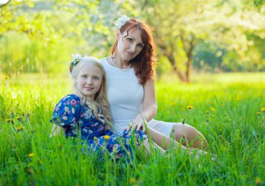 Mutlu bebek kız güzel bir çiçek açan meyve bahçesi elma ağaçlarında beyaz çiçekleri ile annesi ile