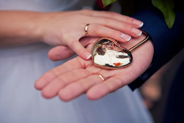 The couple holding hands in a heart-shaped lock — Stock Photo, Image