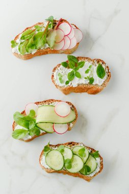 Yumuşak peynirli sandviçler, turp ve salatalık.