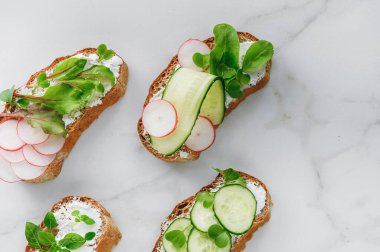 Yumuşak peynirli sandviçler, turp ve salatalık.