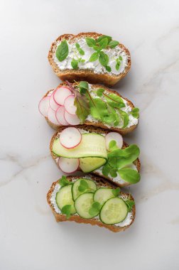 Yumuşak peynirli sandviçler, turp ve salatalık.