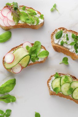 Yumuşak peynirli sandviçler, turp ve salatalık.