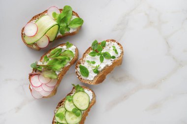 Yumuşak peynirli sandviçler, turp ve salatalık.