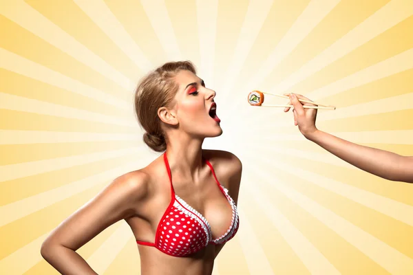 Feed me. A creative retro photo of a young pin-up girl in bikini eating sushi from chopsticks on colorful abstract cartoon style background. — Stock Photo, Image