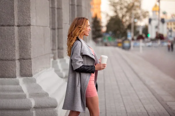 Городской экспрессо. Красивая женщина с кофе, чтобы пойти против городской сцены . — стоковое фото