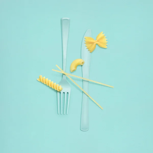 Tasty Italy. Creative still life of fork and knife at a lunchtime with raw pasta served. — Stock Photo, Image
