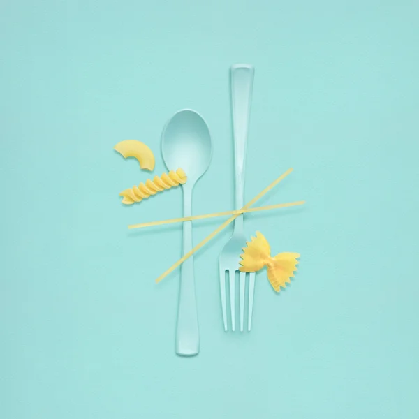 Välsmakande pasta. Kreativ Stilleben av gaffel och sked vid lunchtid med rå pasta serveras. — Stockfoto