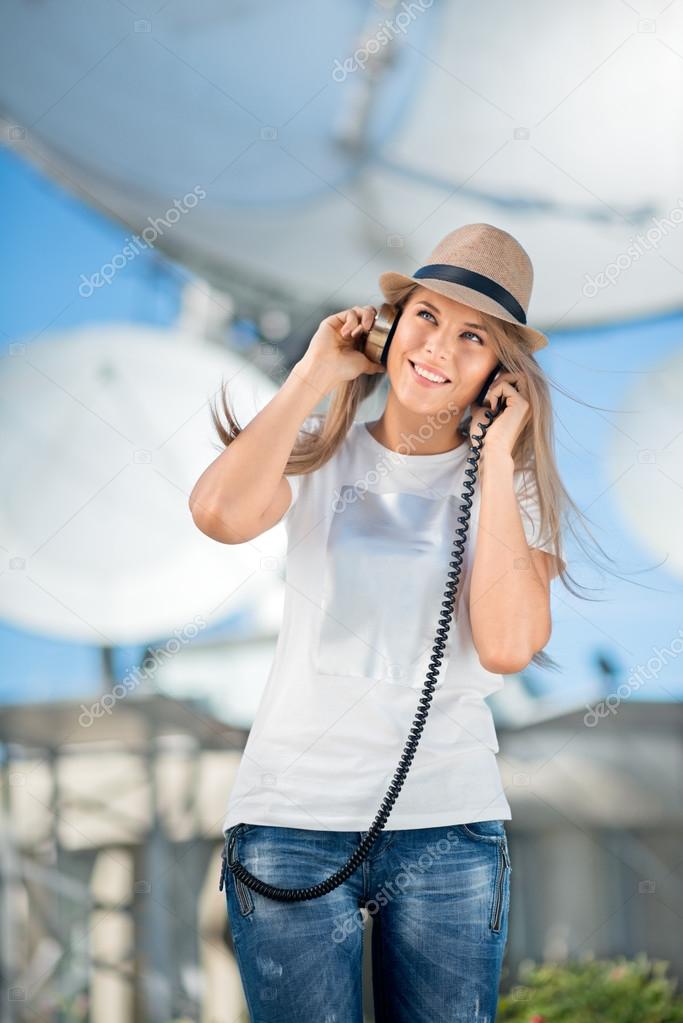 Happy young woman in hat listening to the music in vintage music