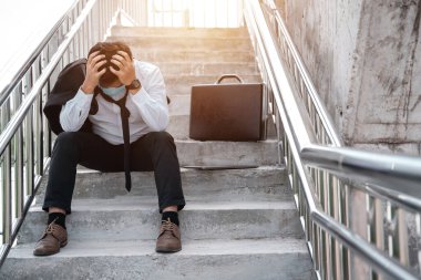 İşsiz, stresli, takım elbiseli Asyalı iş adamı elleri ile yüzünü kapatıyor. Covid-19, iş ve stres hastalığında başarısızlık ve işten çıkarma kavramı. İş adamları düşük ekonomik krizden umutsuzlar