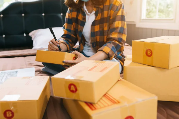 Close up Online shopping young women start small business in a cardboard box at work. The seller prepares the delivery box for the customer, online sales, or ecommerce.