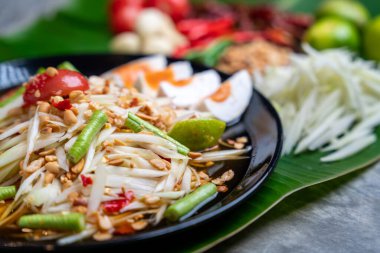 Som Tam Thai ve Papaya salatası ve muz yaprağı üzerine tuzlu Tayland yemeği. Tayland Gıda Konsepti. 