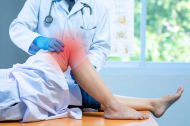 Yakın plan eldiven giyen doktor, klinikte diz sorunu olan hastaların başındaki tıbbi ortopedik tedavi kavramını inceliyor.