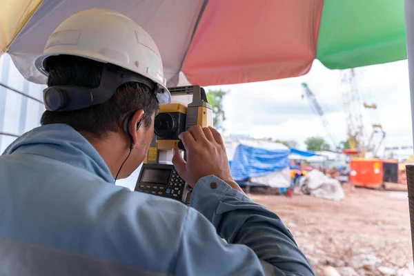 新しい建設現場での測量作業中に測量技師のテオドライト装置 — ストック写真