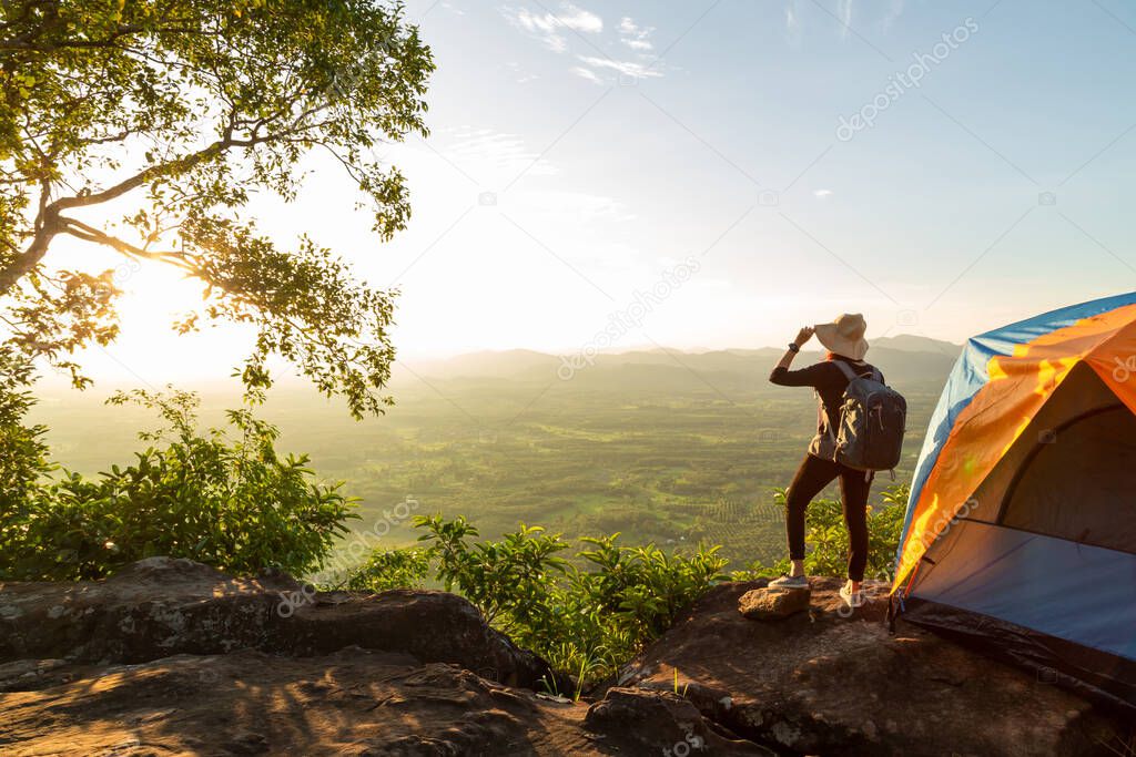 Silhouette of woman travel relax camping in autumn holiday. On top of moutain. Enjoy sunrise, The concept life of freedom.