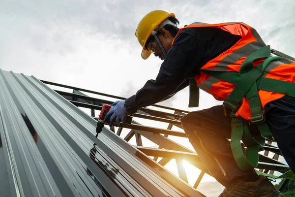 Çatı inşaatı, Asyalı işçiler yeni çatı döşemesi, çatılarda elektrikli matkap ve inşaat alanında metal levha..
