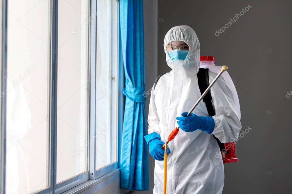 Portrait of man wearing PPE  hold a spay to prevent diffusion coronavirus protective suit, Covid-19 nCov2019 spread prevention