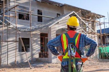 Çatı inşaatı, işçilerin çatıya monte edebileceği yükseklik ekipmanları. İnşaat alanında emniyet kemeri için kancaları olan işçilerin tutuklanma cihazını düşür.