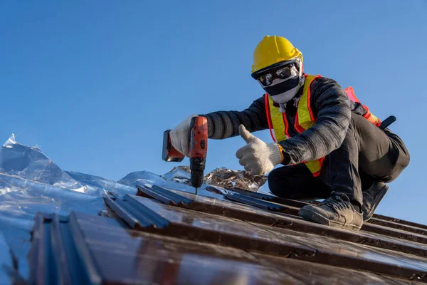 Confident roof construction, Worker install new ceramic tile roof with Roofing tools electric drill used in the construction site.