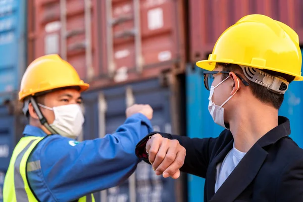 亚洲工业建筑工地工人和工头头戴卫生面具肘部凸起问候适应 以防止考罗内韦尔斯或科维德19型病毒在新常态仓库蔓延 — 图库照片