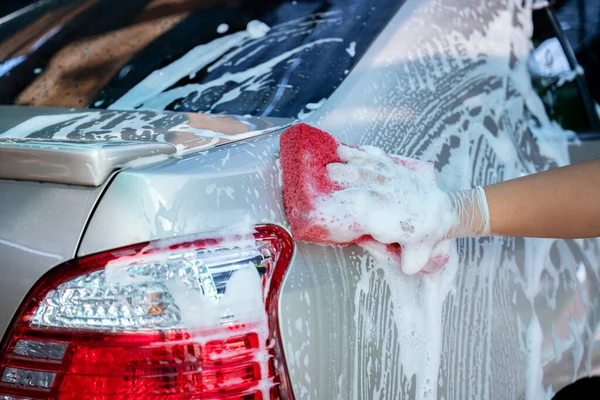 close up hand wear gloves of hold sponge over the car for washing, Car wash service concept.