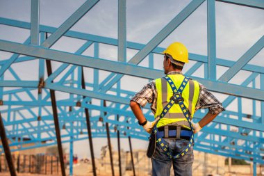 Çelik çatı yapısını izleyen mühendis teknisyen, Bitmemiş İnşaat Projesini inceleyen mühendis teknisyen..