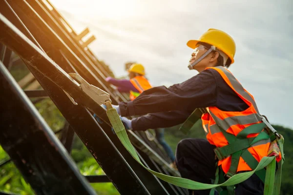 Safety body construction, Engineer technician Working at height equipment. Fall arrestor device for worker with hooks for safety body harness on selective focus. Worker as in construction background.