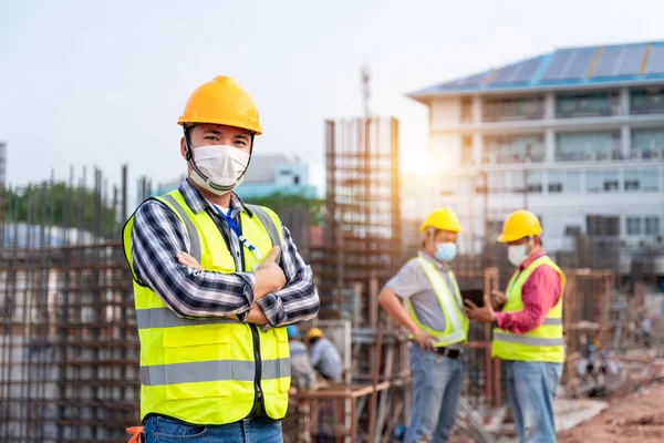 Team work of Construction engineers technician and  architect supervising progress stand in control of building foundations project at construction site