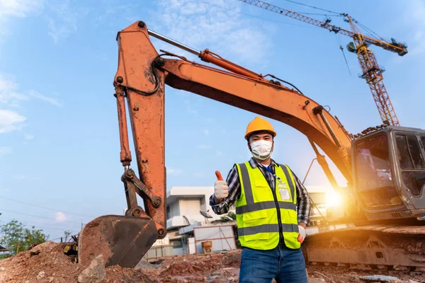 Haapy foreman construction excavator, engineer or worker backhoe driver and crane wearing a safety suit  at construction site