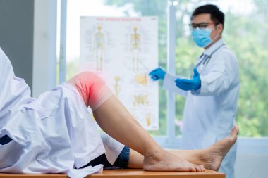Seçici odaklanma diz, ortopedik doktor eldiven giyer doktor klinikte diz iltihabı olan hastanın başını muayene eder.. 