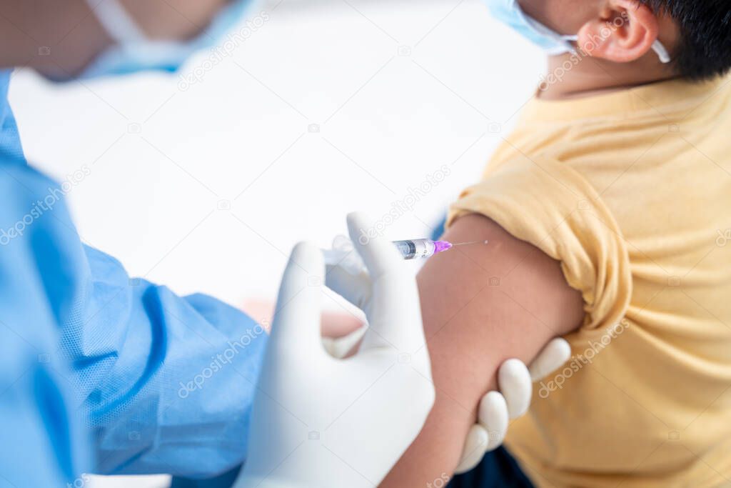 Doctor making a vaccination in the shoulder of patient boy or child person,Flu Vaccination Injection on Arm, coronavirus,covid-19 vaccine disease preparing for human clinical trials vaccination shot