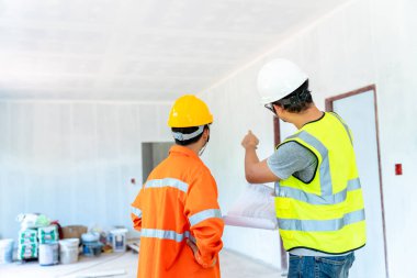 İnşaat alanındaki müşterilere kaliteli konut göndermeden önce ustabaşıyla birlikte mimar ve mühendis konut inşaatını başarı inşaatı planına göre inceler.