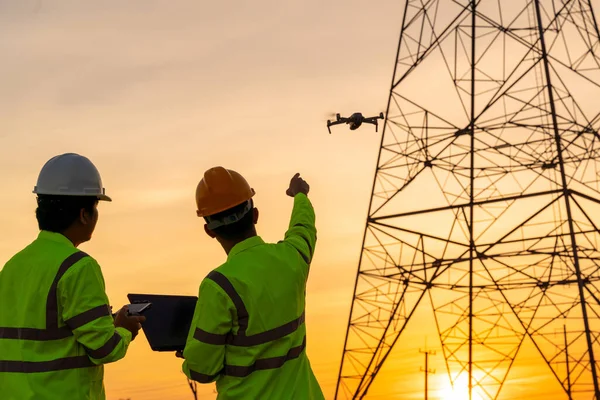 Mühendislerin konumu teknisyenlerin elektrik santralindeki denetimleri gerçekleştirmek için gün batımında yüksek voltajlı elektrik iletim kulesi üretmek suretiyle İHA 'yı kullanmasına yardımcı oluyor.