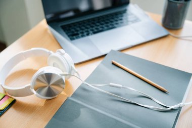 Çevrimiçi öğrenme ekipmanlarının en üst görüntüsü, evdeki online dersi sırasında bilgisayar ve kulaklık kavramı, karantina sırasında sosyal uzaklık, notlar, Uzak Ev Eğitimi.