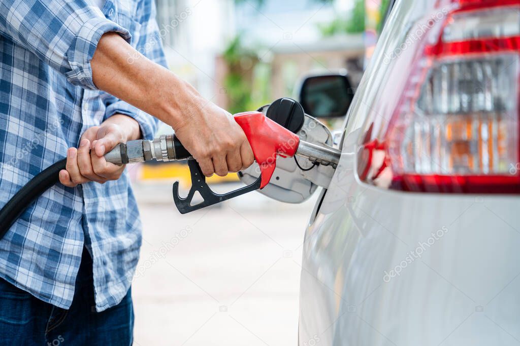 close-up hand of refuel the car by yourself, Pumping equipment gas at gas station.