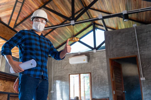 Happy asian construction engineer technician inspect the wood structure under the roof at construction site or building site of a house.