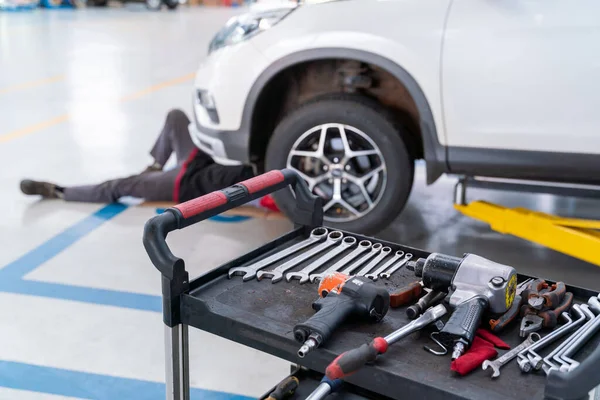 select focus equipment of car mechanic adjusting tension in vehicle suspension Element at auto repair service center, car suspension concept
