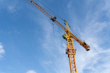 Endüstriyel inşaat vinçlerini ve mavi gökyüzüne inşa edilen ağır makine şantiyesini kapatın.